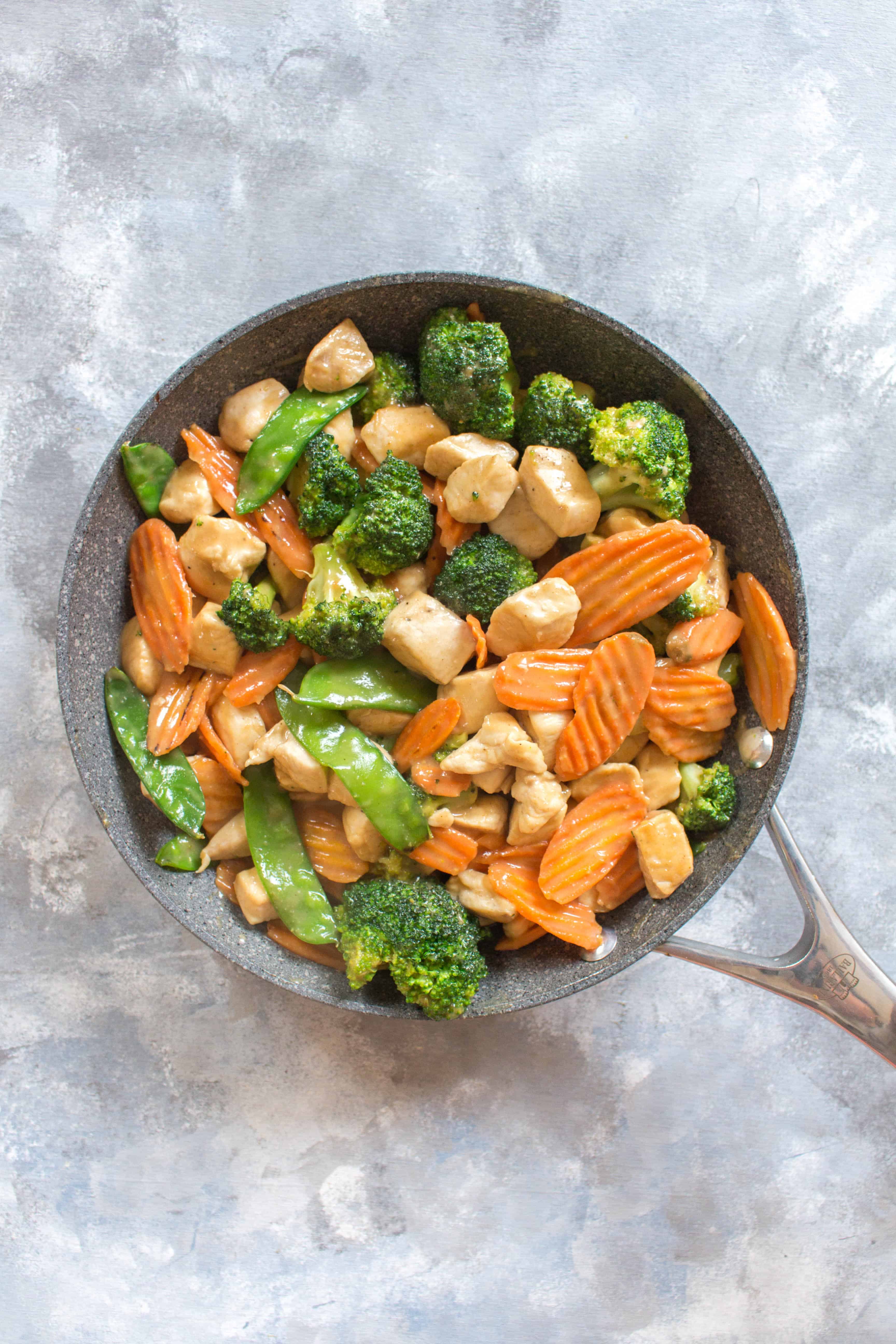 Craving a delicious satay stir fry from your local take out place? Skip the take out and make your own healthy chicken and vegetable stir fry with peanut sauce. It takes less than 30 minutes and you can pack the leftovers as a work lunch!