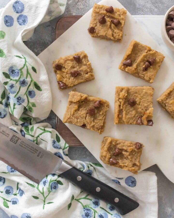 A cross between fudge and brownies, this Flourless Healthy Chickpea Peanut Butter Blondies is a guilt-free treat that takes next to no time to whip up! #healthydesserts #