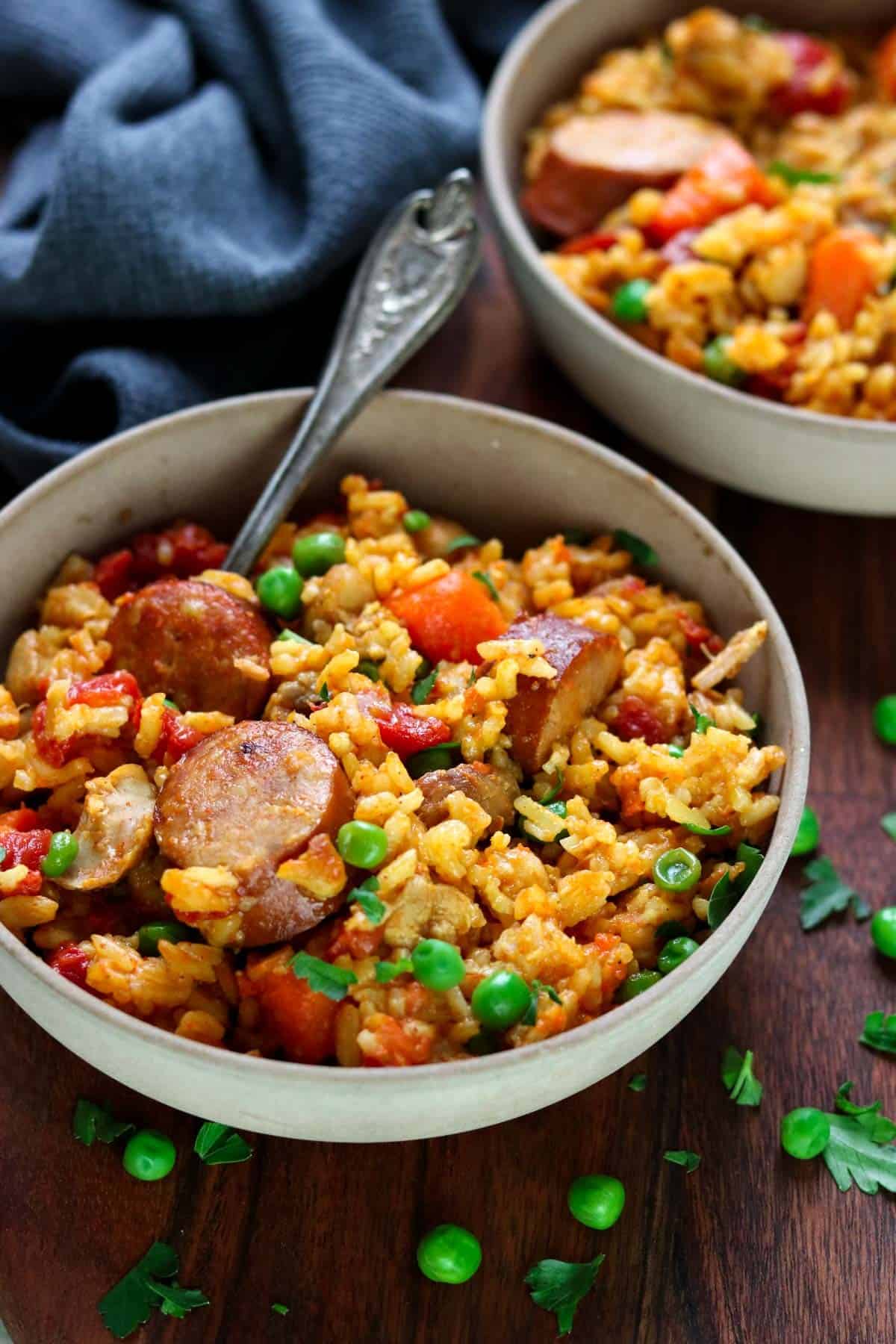 You are going to love this recipe for Instant Pot Cajun Rice with Chicken and Sausage. It is deliciously full of rice, has the sweet flavors of carrots and tomatoes, the fresh snap of green peas, and the wonderful spices of cajun seasoning. The andouille sausage adds a layer of heat and the chicken comes out tender and flavorful. It is perfection in one bowl!