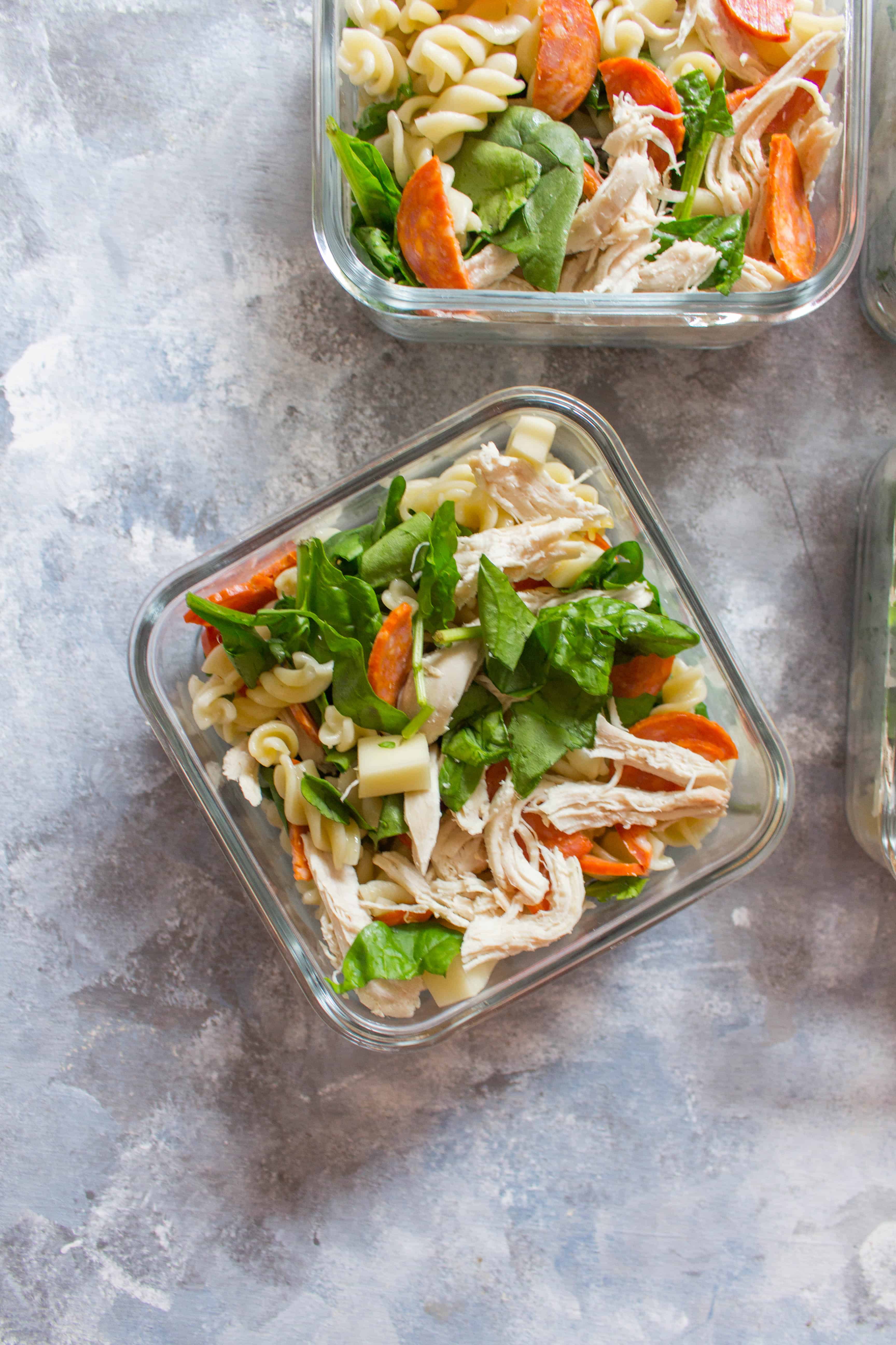 Close up of the pepperoni pasta salad in a square glass container | Perfect for hot summer days, this easy chicken pepperoni pasta salad is just what you need! Plus, this pasta salad is great for meal preps if you have don't have access to a microwave.