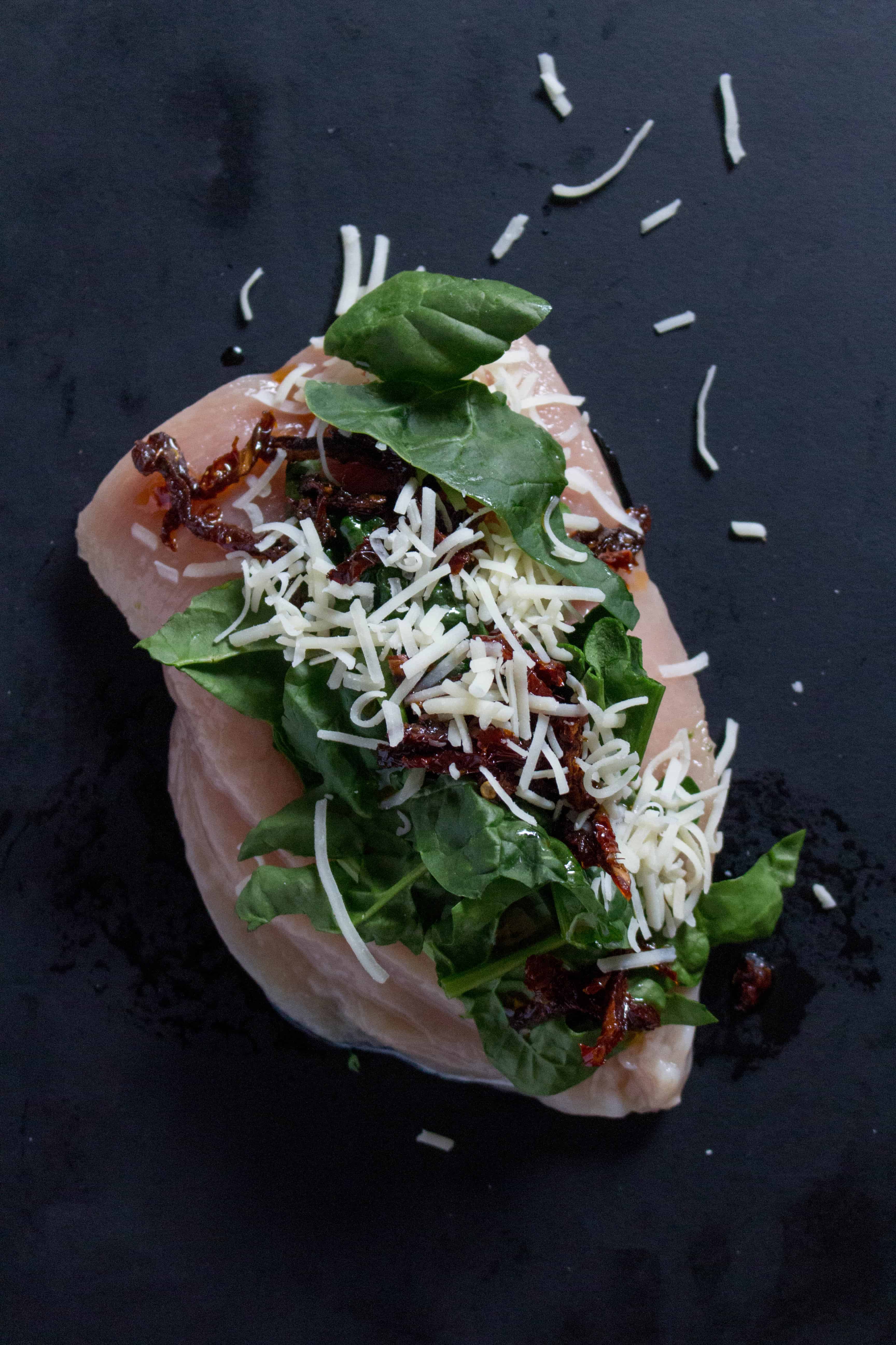 How to stuff chicken breast - butterflied chicken breast with sun dried tomatoes, spinach, and cheese | Looking to change up your regular boring chicken meal prep? This Spinach, Sun Dried Tomato, and Cheese Stuffed Chicken Meal Prep will have you asking for more as it is stuffed with flavour without having to spend time marinating!