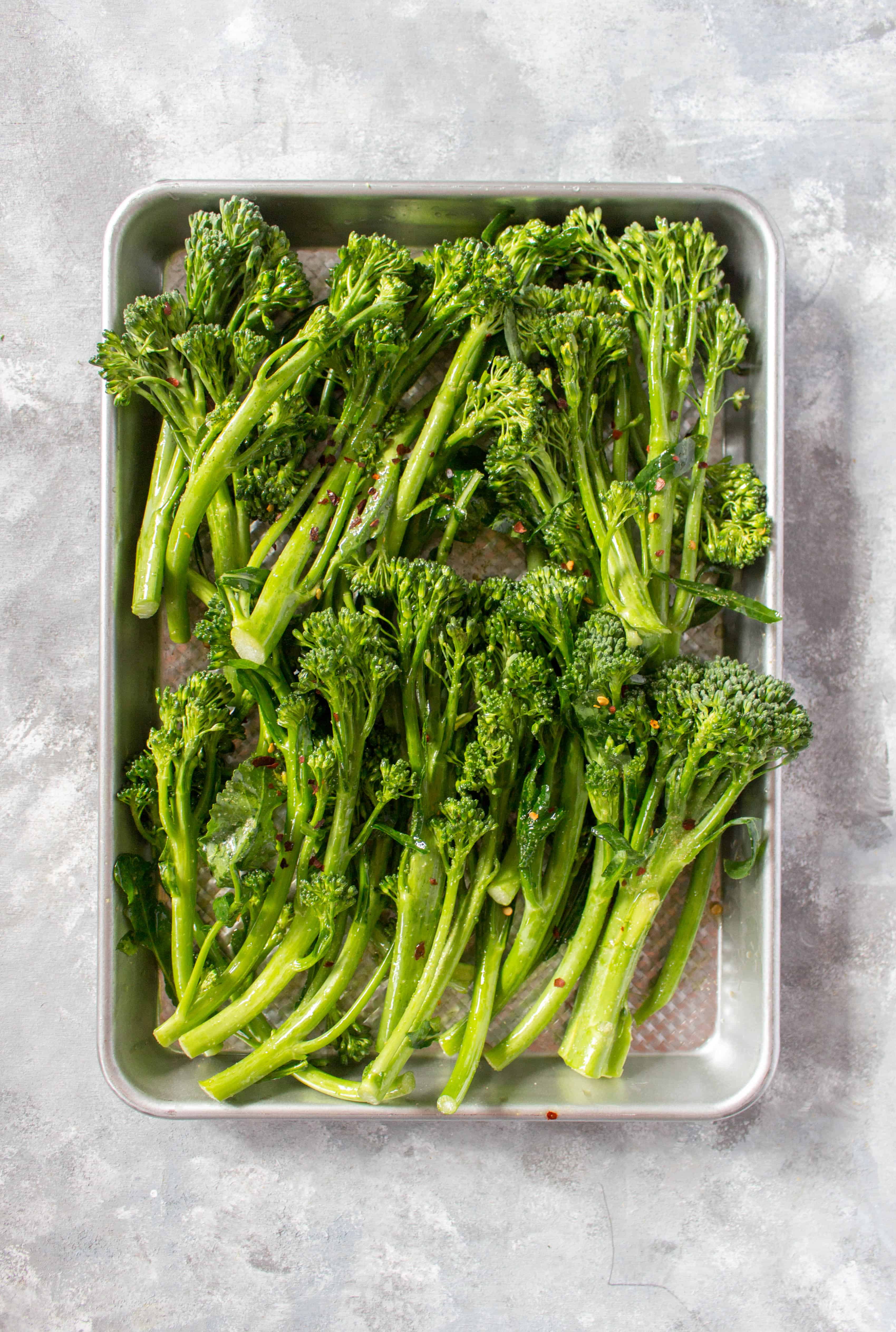 broccolini on a sheet pan ready for roasting.