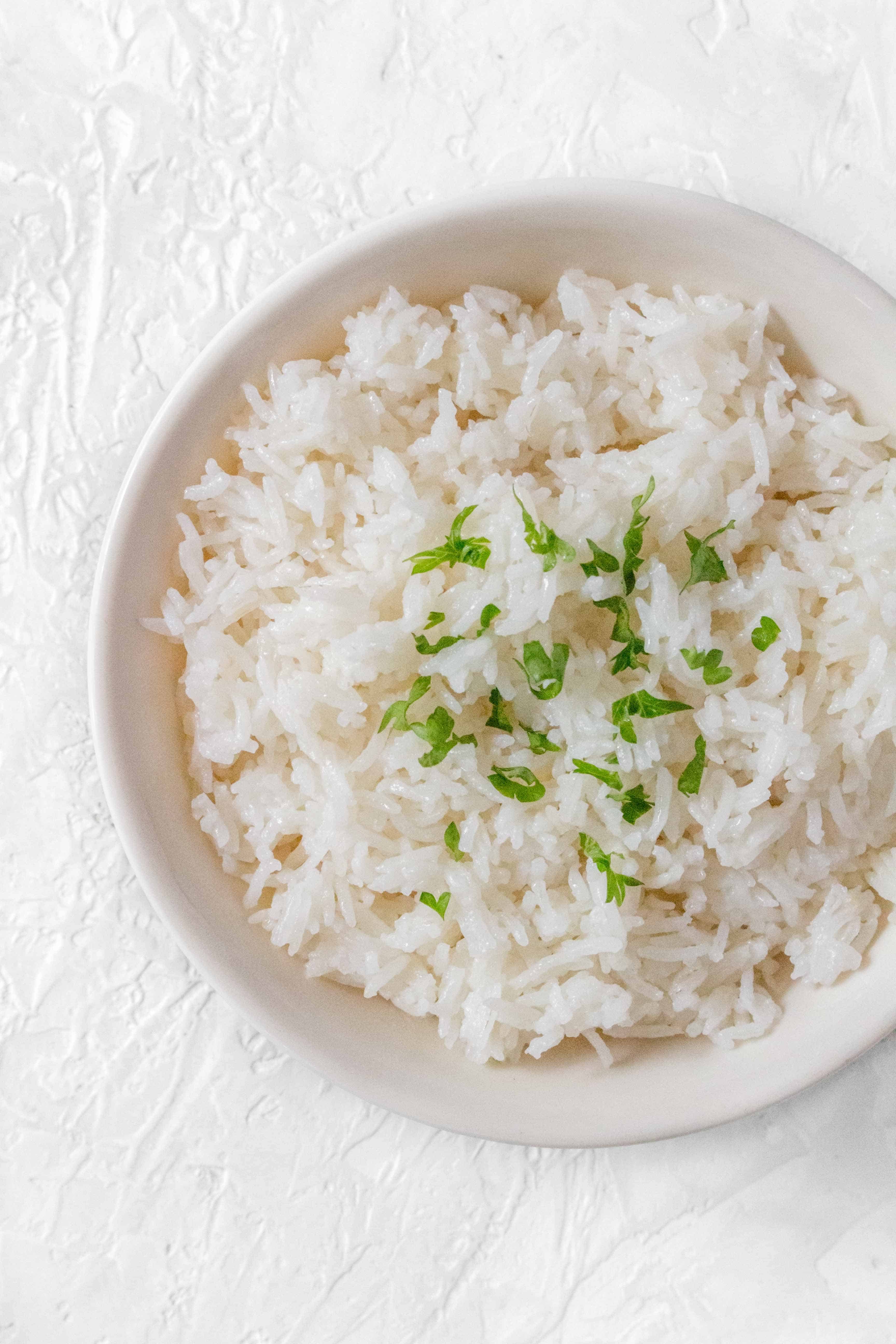 A bowl of coconut lime rice with garnish on top.