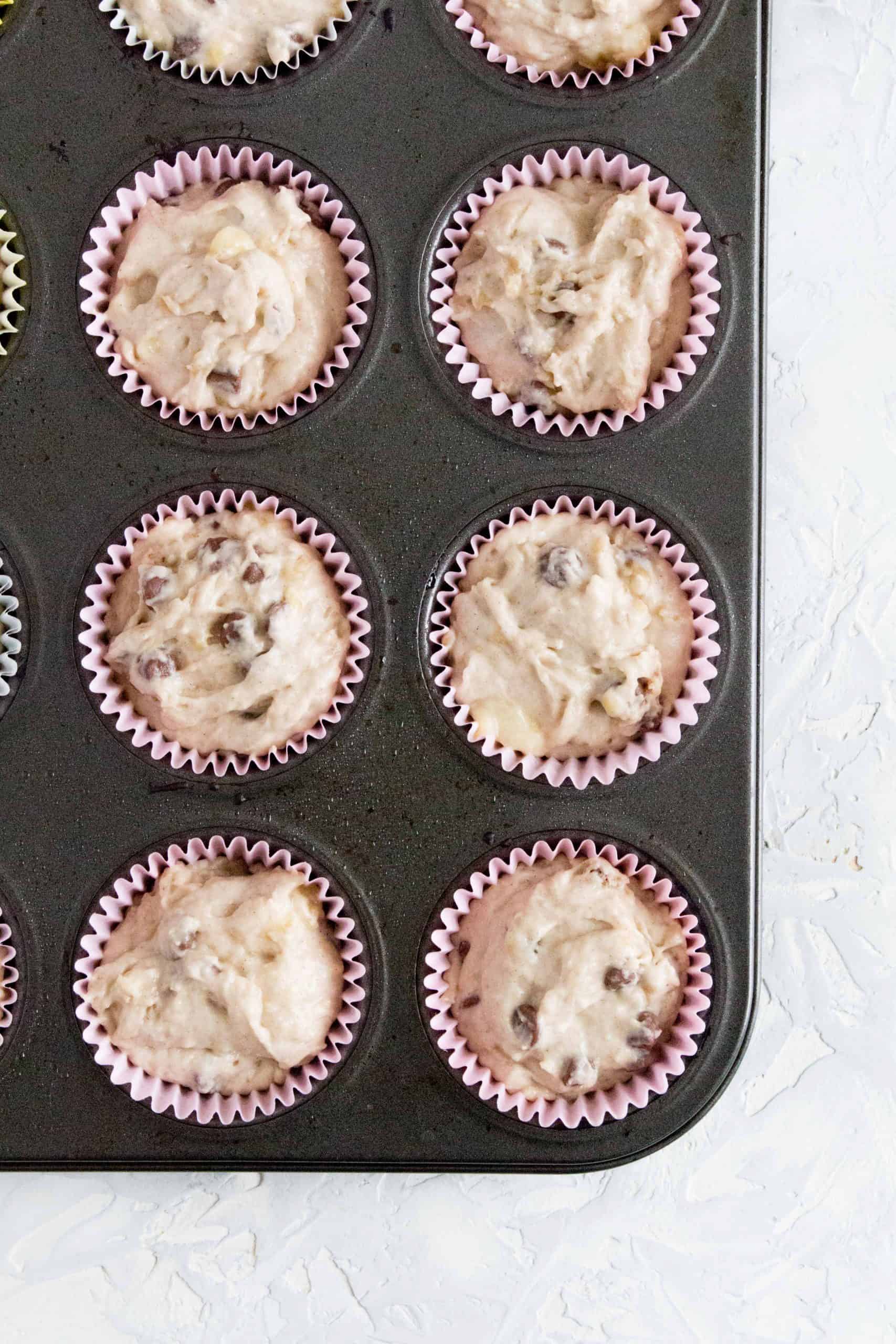 banana chocolate chip muffin mix in liners in a muffin pan