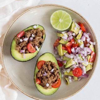 Tacos... but with an avocado. It's hard to go wrong with this switcharoo! Load up the halved avocados with the easiest taco meat and toppings of your choice for an easy dinner tonight!