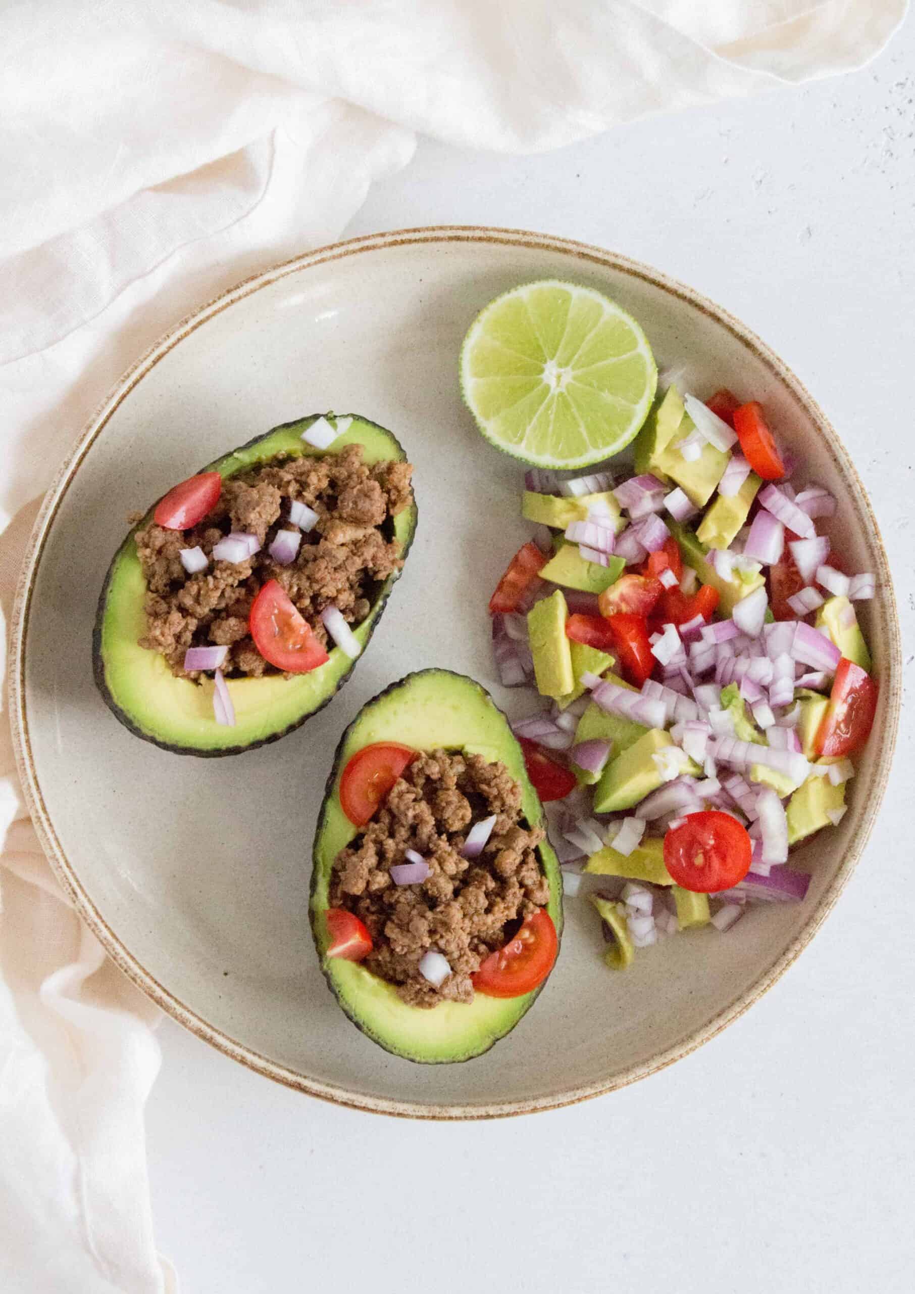 Tacos... but with an avocado. It's hard to go wrong with this switcharoo! Load up the halved avocados with the easiest taco meat and toppings of your choice for an easy dinner tonight!
