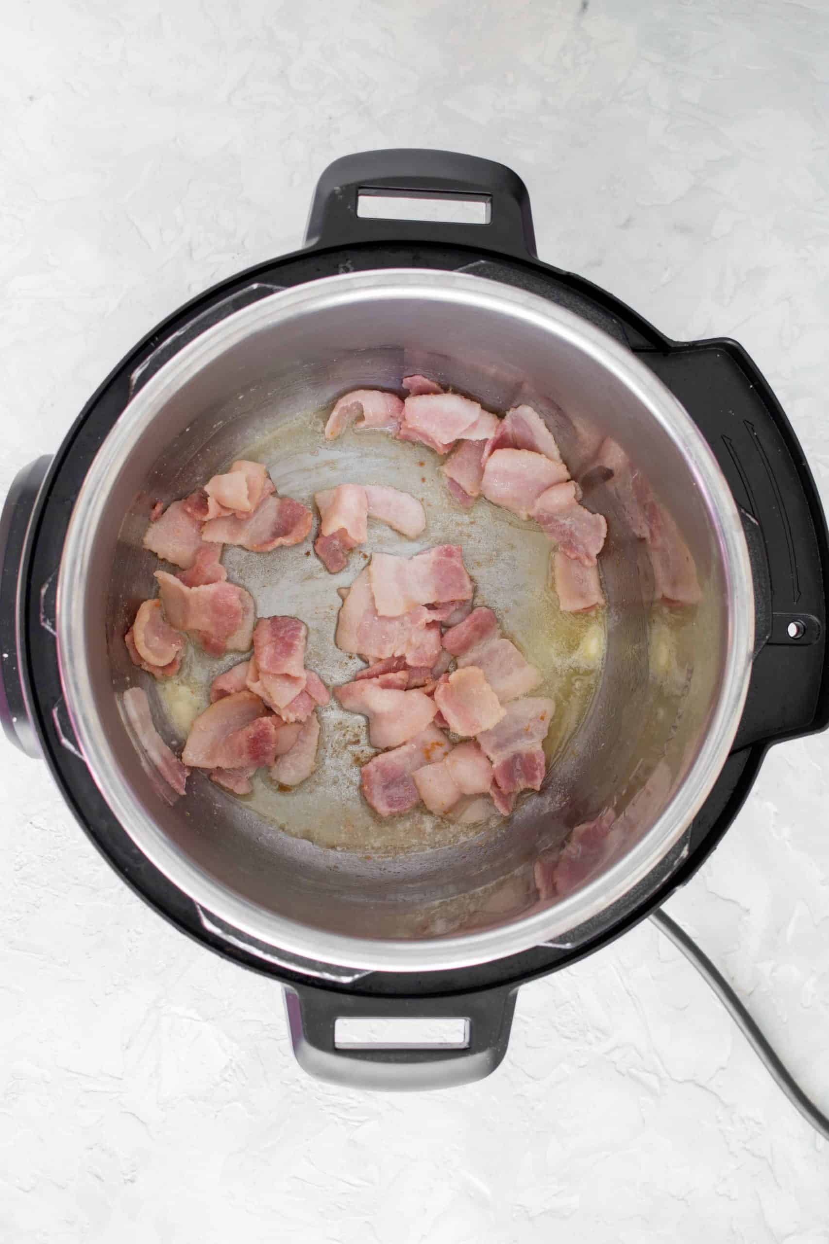 On sauté mode, add in your cut up bacon. Cook it for 2-3 minutes.