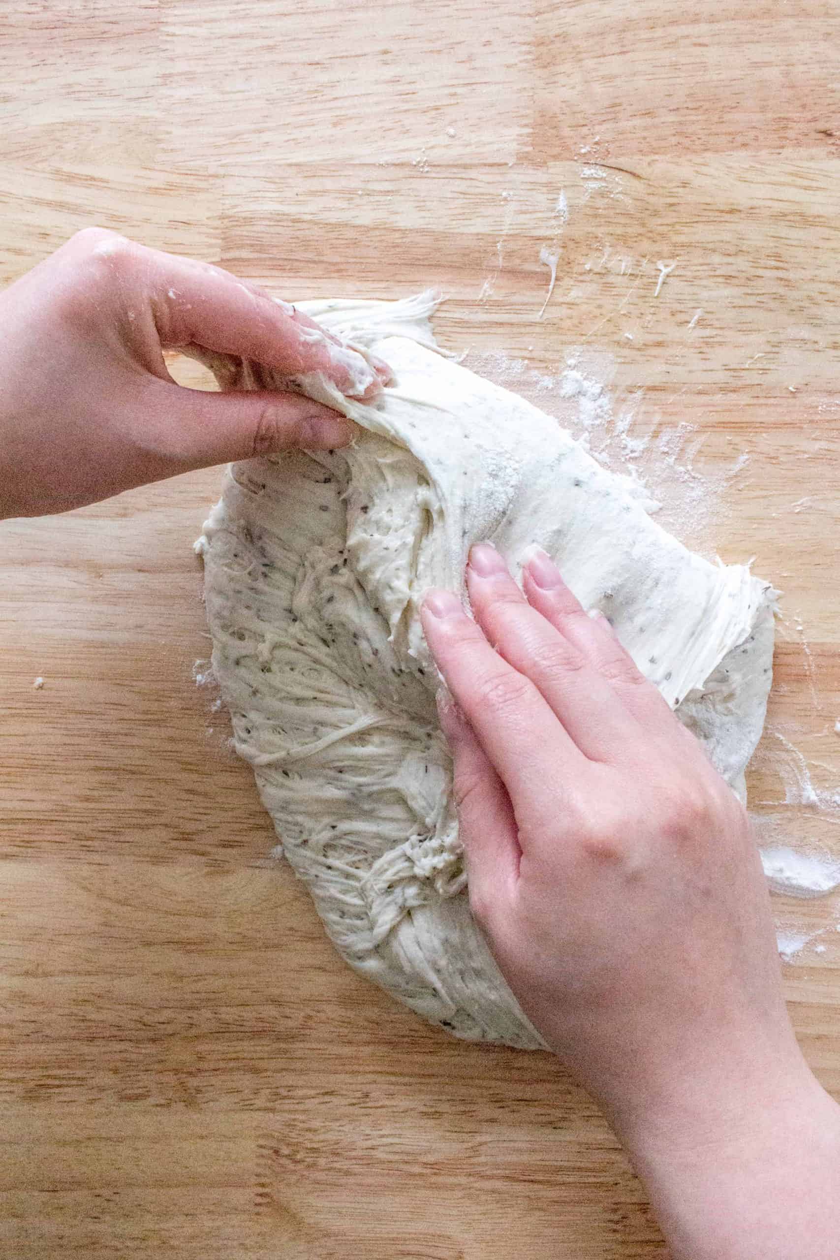 Lightly flour your kitchen counter, gently remove the dough from the bowl onto the counter, and gently fold the dough into a round ball. I fold the dough from the sides and gently tuck the bottoms in with my fingertips.