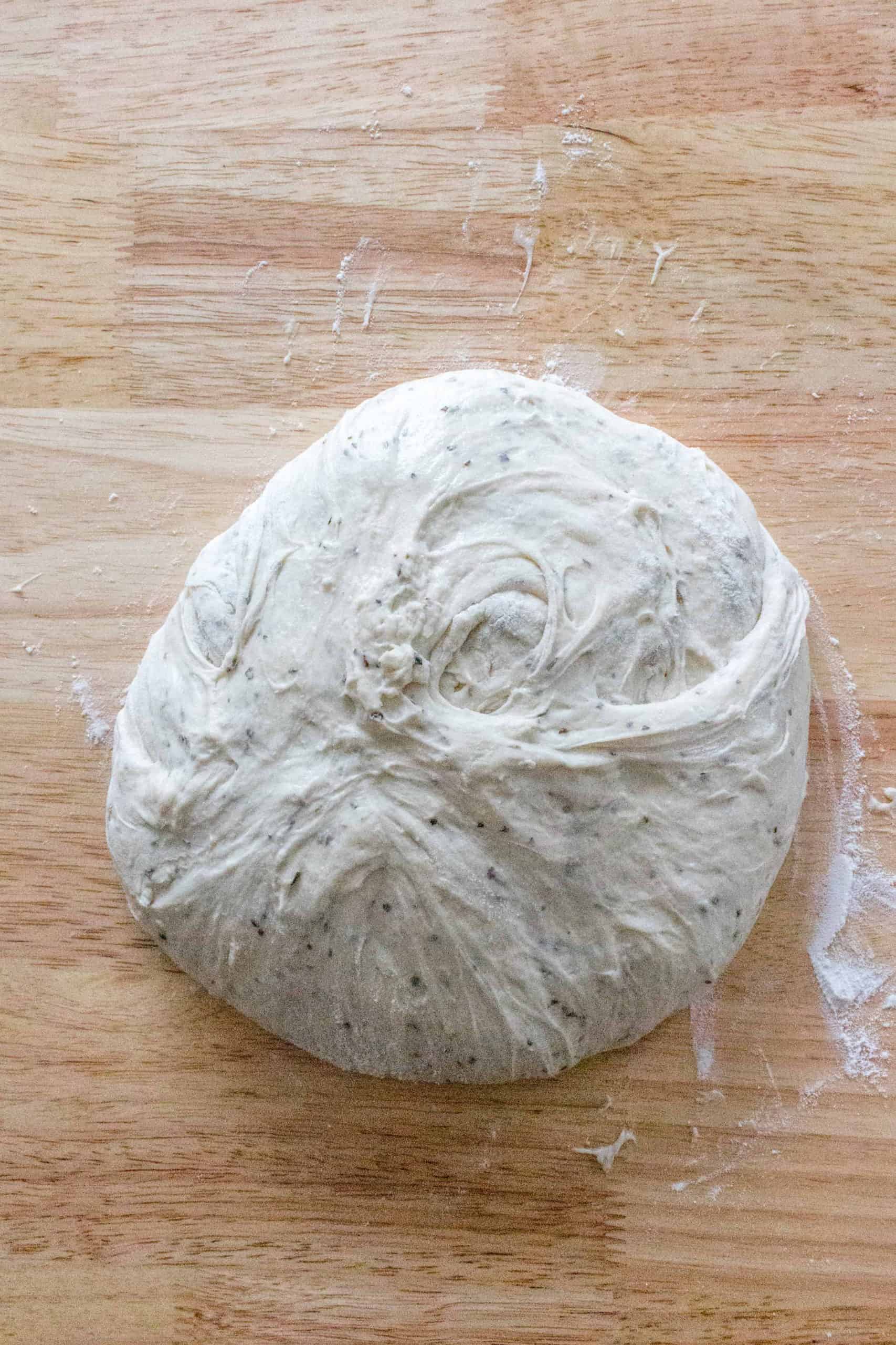 Lightly flour your kitchen counter, gently remove the dough from the bowl onto the counter, and gently fold the dough into a round ball. I fold the dough from the sides and gently tuck the bottoms in with my fingertips.