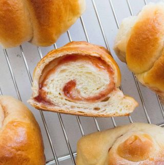 Here's how you can make strawberry swirled, fluffy, pillowy soft Hokkaido style milk bread rolls at home with this simple recipe. The perfect make ahead bread as they stay soft for days! Try these Japanese Milk Bread Rolls tonight!