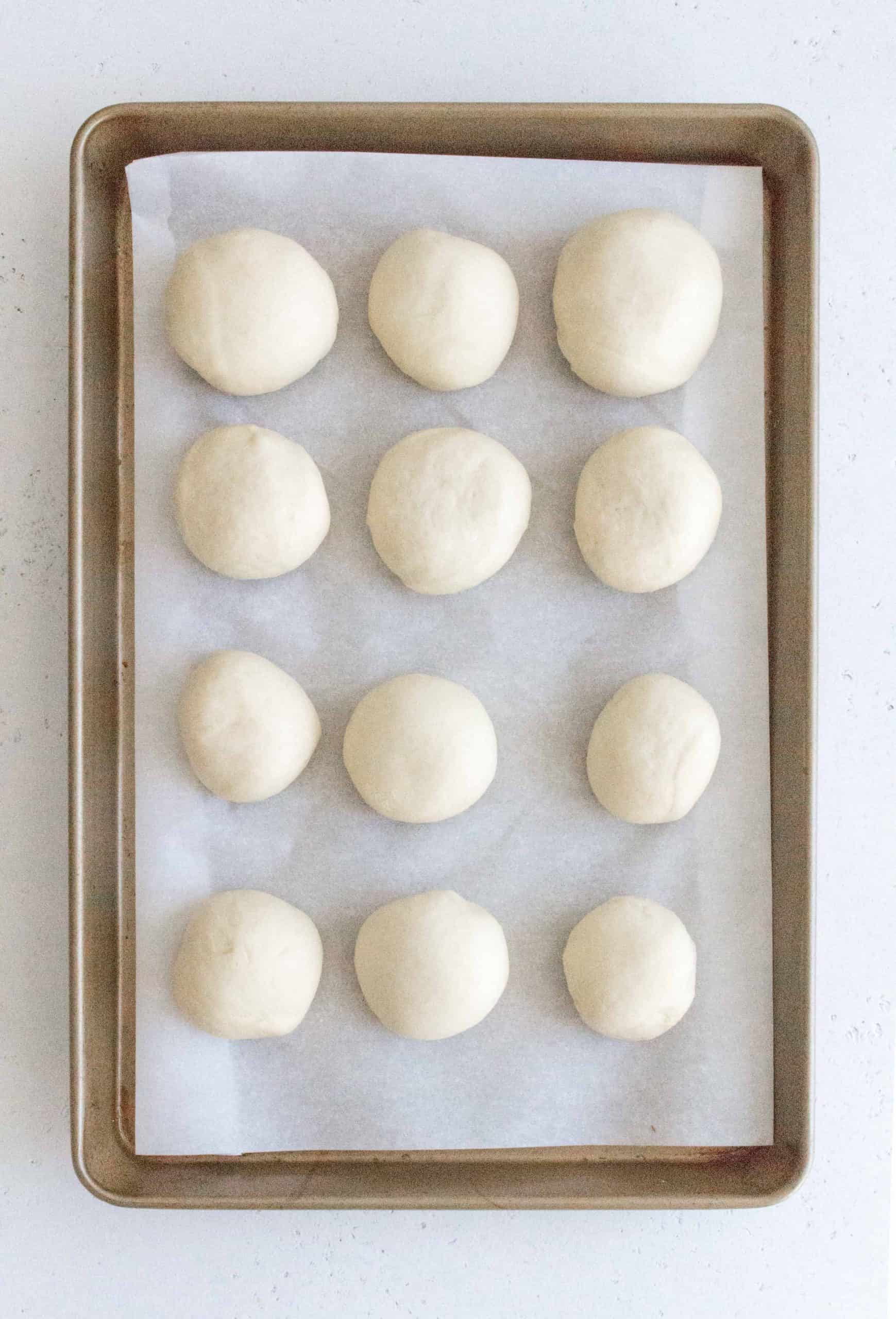 Place the dough balls into a grease 9x12 pan, cover, and let proof for 10 minutes.