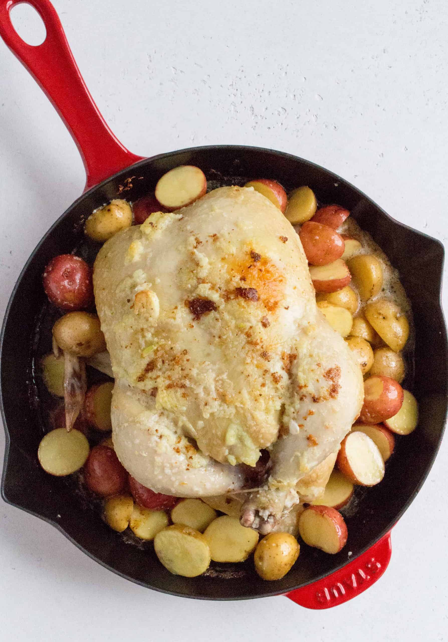 Bake for 10 minutes before pulling out the skillet. Baste the chicken with the melted butter in the pan (by spooning melted butter onto the top of the chicken) before adding in the baby potatoes around the chicken. Sprinkle some salt on and make sure the potatoes are coated in butter and salt.