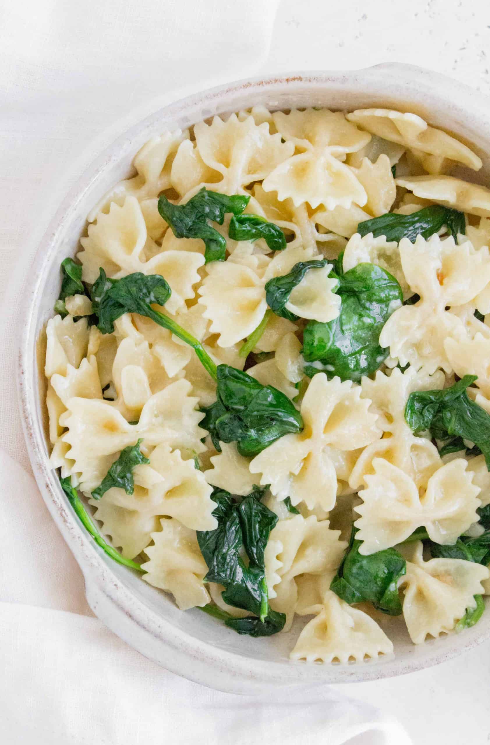 bowl with bow tie pasta with garlic and spinach with a butter sauce