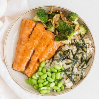 plate with teriyaki salmon with broccoli, edamame, brown rice, and seaweed