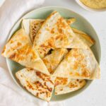 green plate with chicken and hummus quesadillas