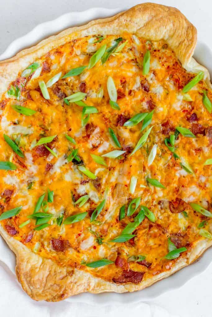 korean quiche made with puff pastry and kimchi with green onions, bacon, and cheese