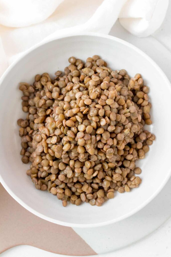 cooked green lentils in a white bowl