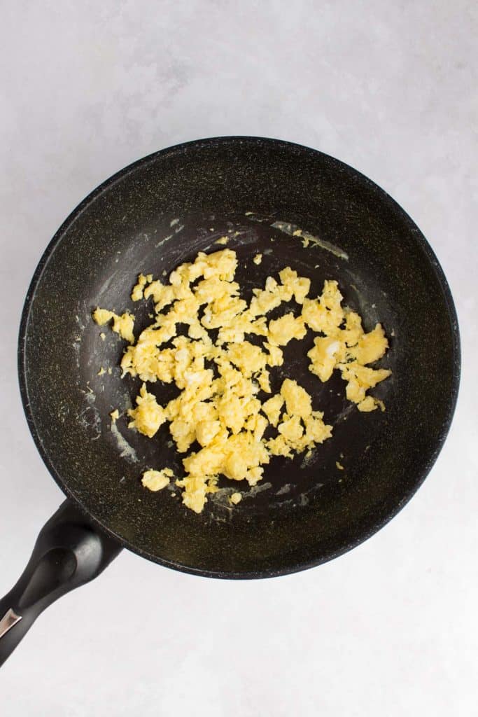 Instructional photo showing scrambled eggs in a wok.