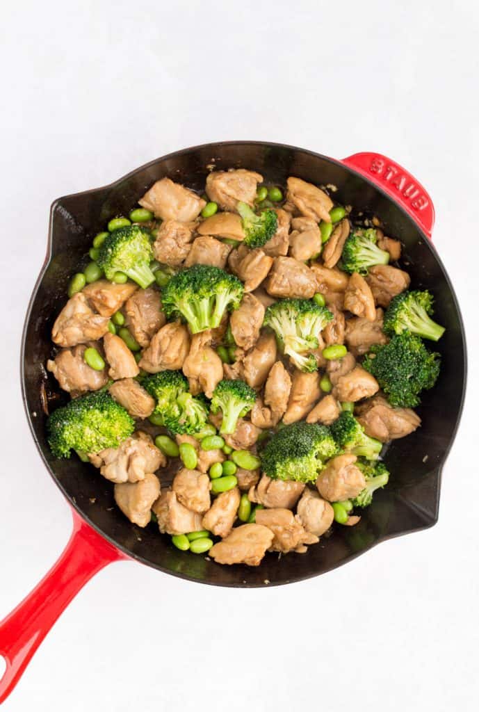 sesame chicken with broccoli and edamame in a skillet.