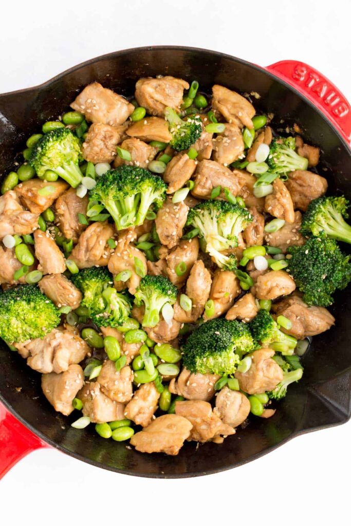 close up image of sesame chicken with broccoli in a skillet.