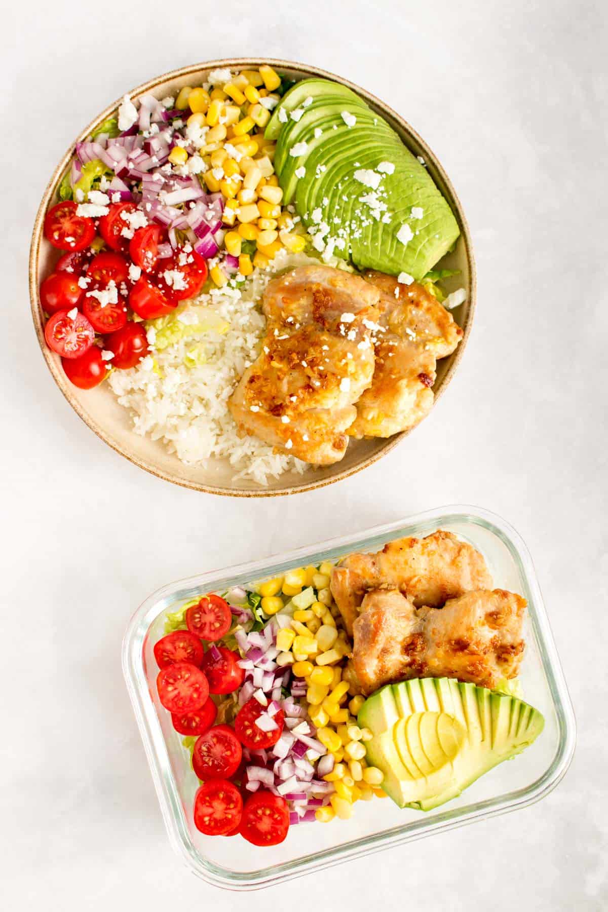 A plate with a chicken rice bowl and a meal prep container of a garlic butter chicken thigh salad bowl.