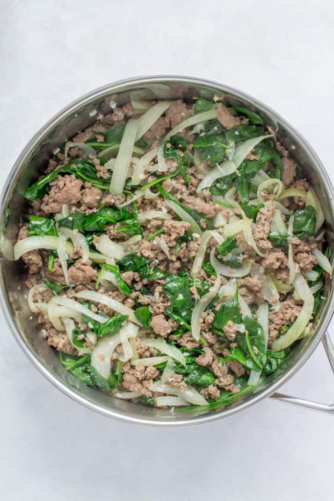 Pan with beef, onions, garlic, and spinach.