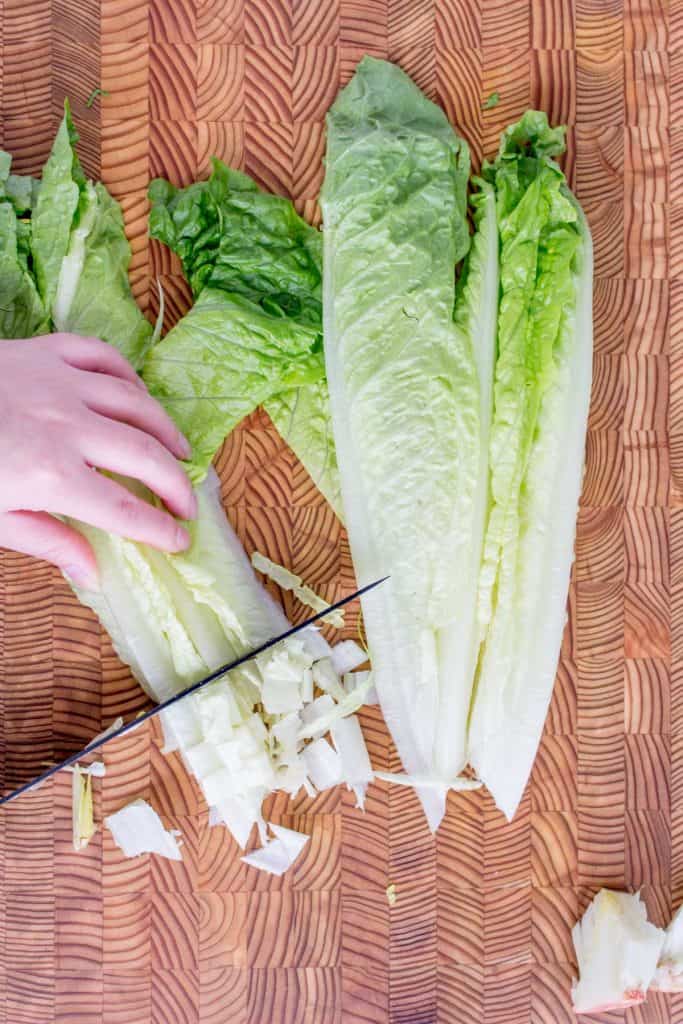 Dicing romaine lettuce into bite sized pieces.