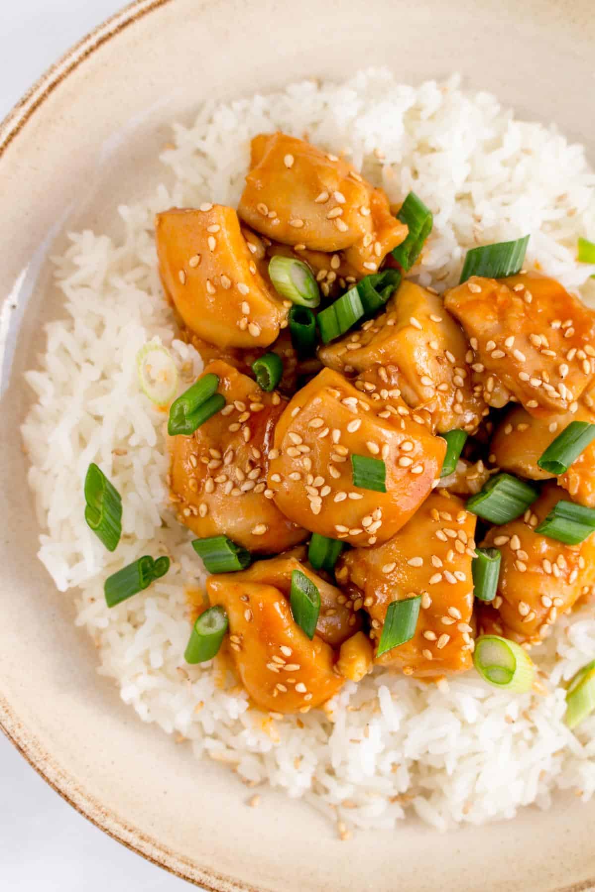 Close up of a plate of rice with instant pot sesame chicken on top.