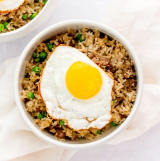 Bowl of beef fried rice with a fried egg on top.