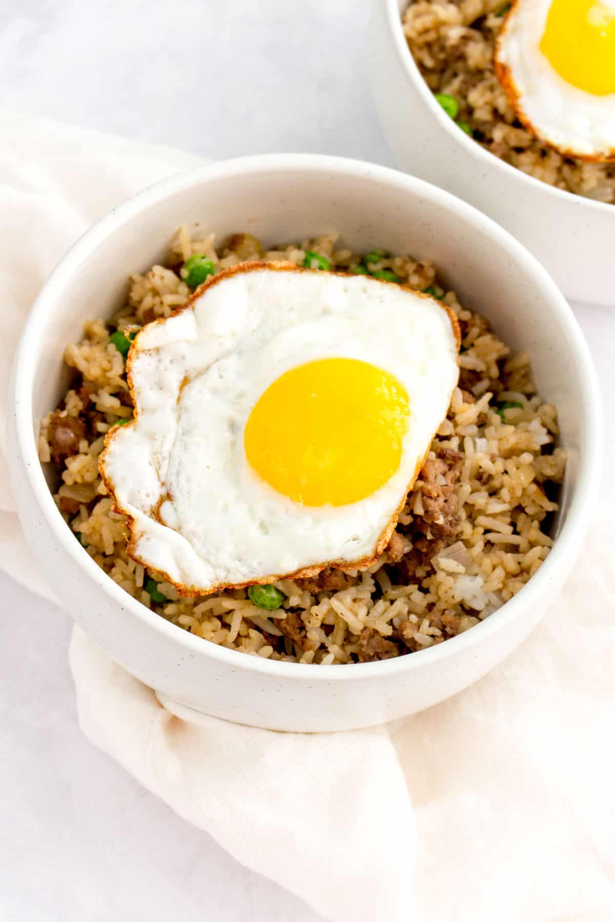 Bowl of beef fried rice with a fried egg on top.