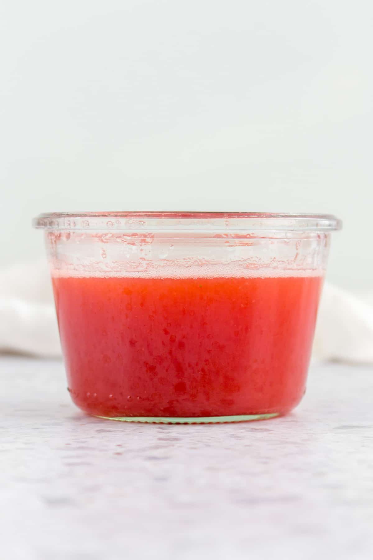 A jar of strawberry basil syrup.