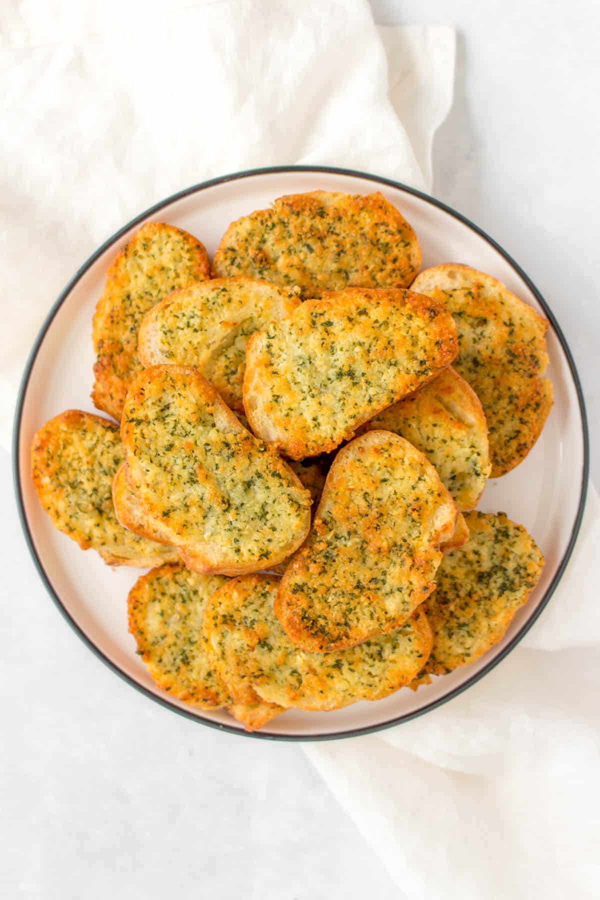 Overhead view of garlic bread on a plate.