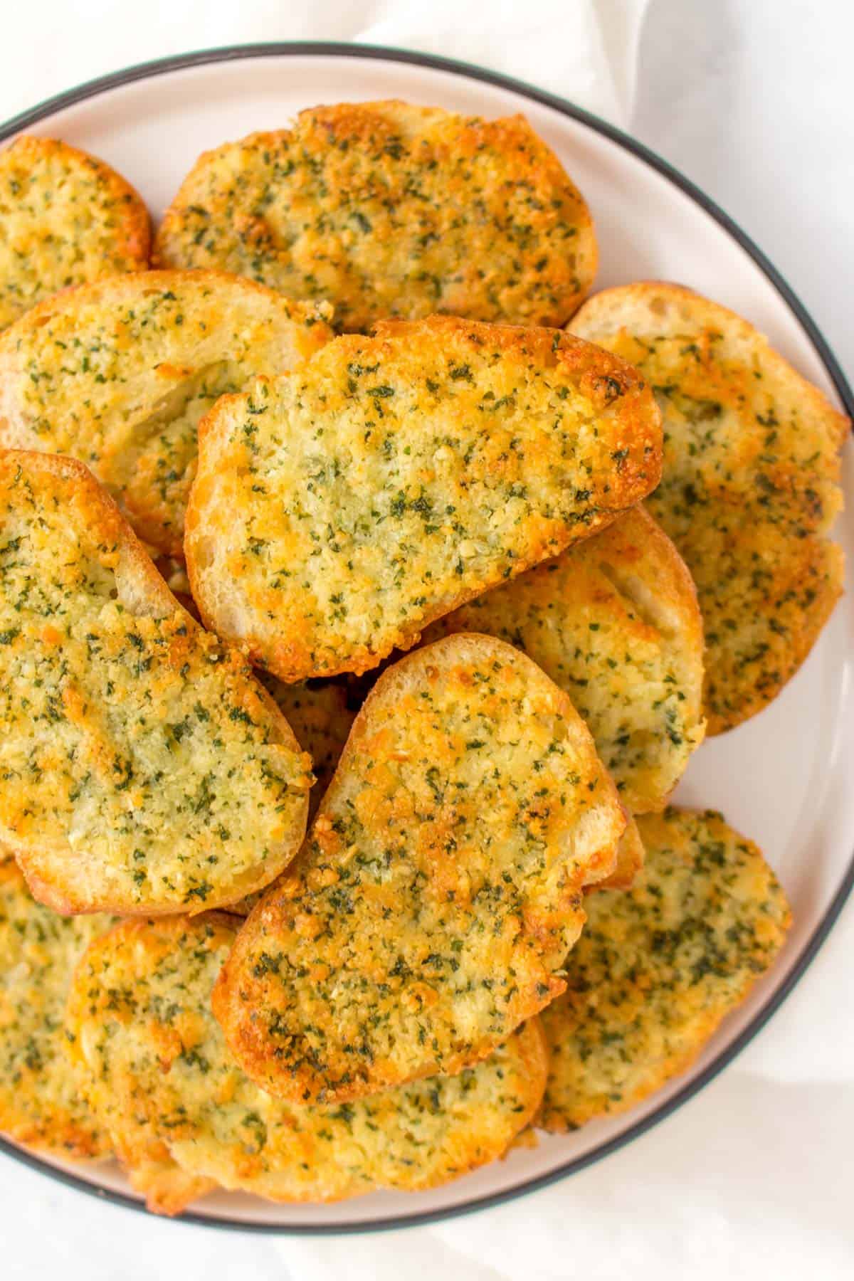 Close up of a stack of garlic bread on a plate.