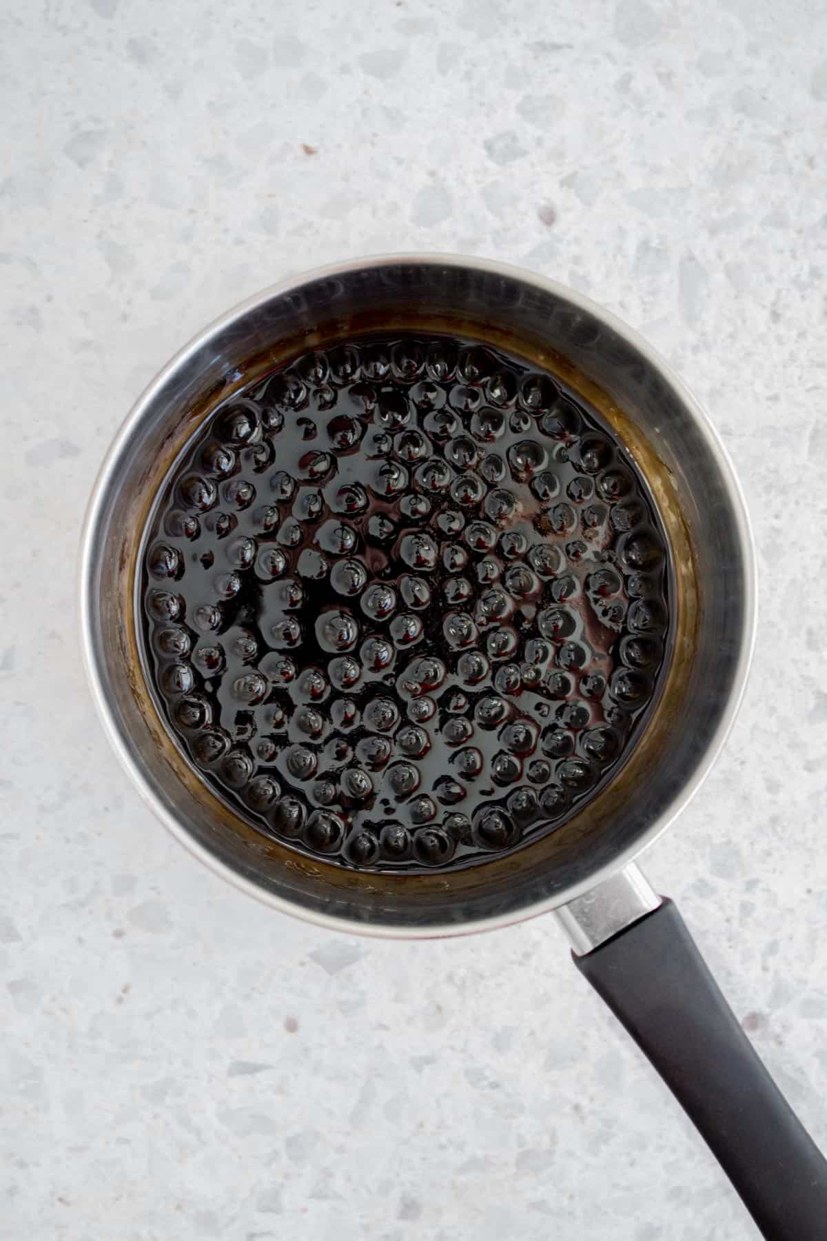 A pot of brown sugar syrup with tapioca pearls in a pot.