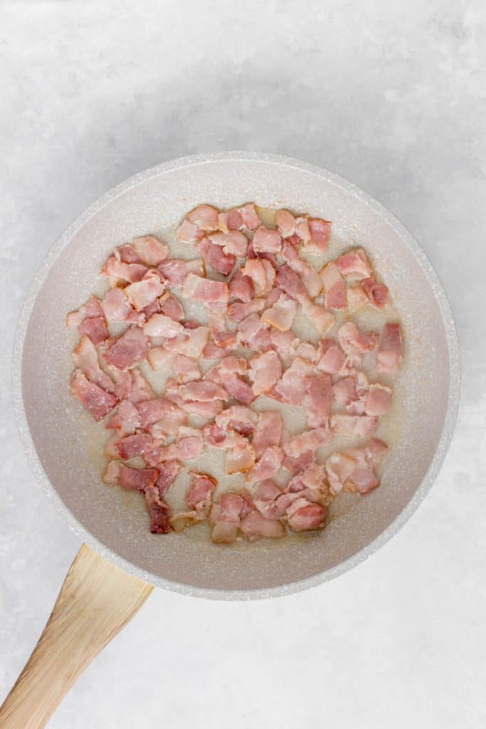 Bacon cooking in a skillet.
