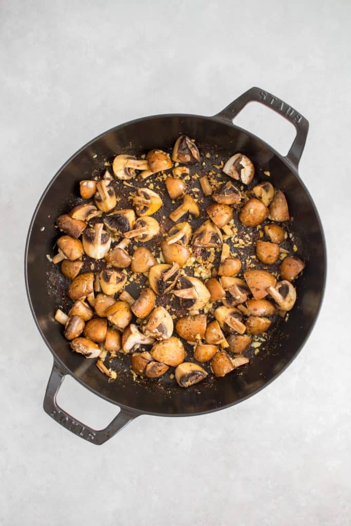 Garlic and mushrooms sautéed in a pan.