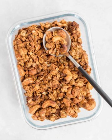Granola in a glass meal prep container.