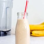 Roasted banana cinnamon milk in a glass with a straw.
