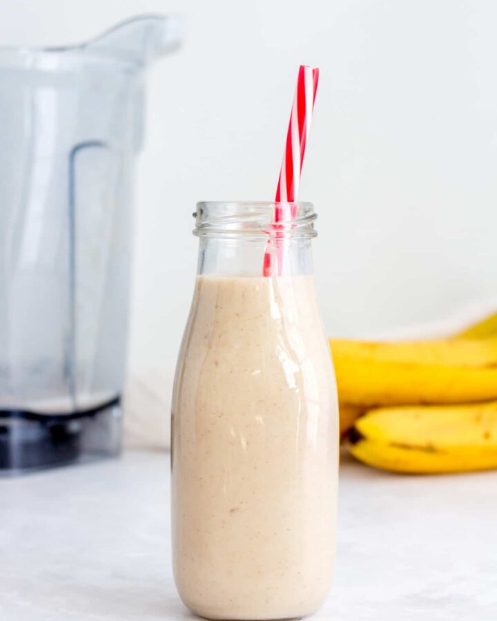 Roasted banana cinnamon milk in a glass with a straw.