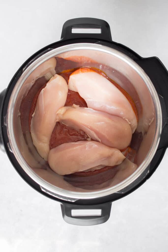 Chicken breasts added to an Instant Pot.