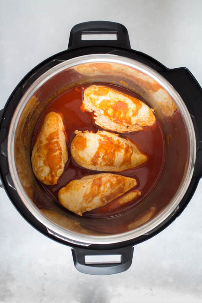 Cooked buffalo chicken in a pressure cooker.