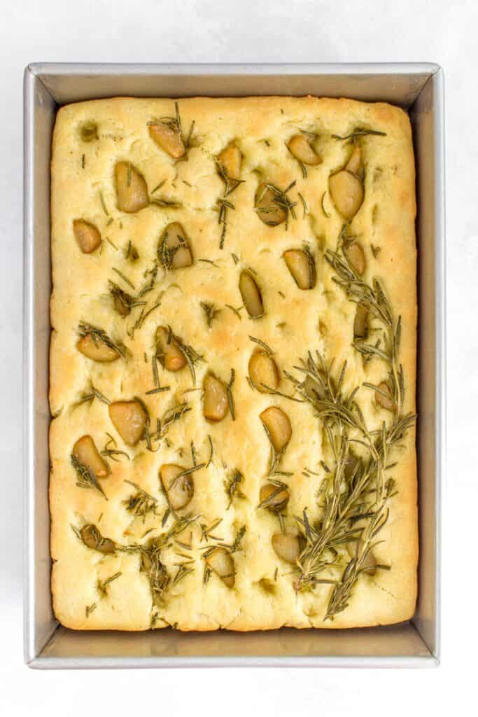 Baked rosemary and garlic focaccia bread in a pan.