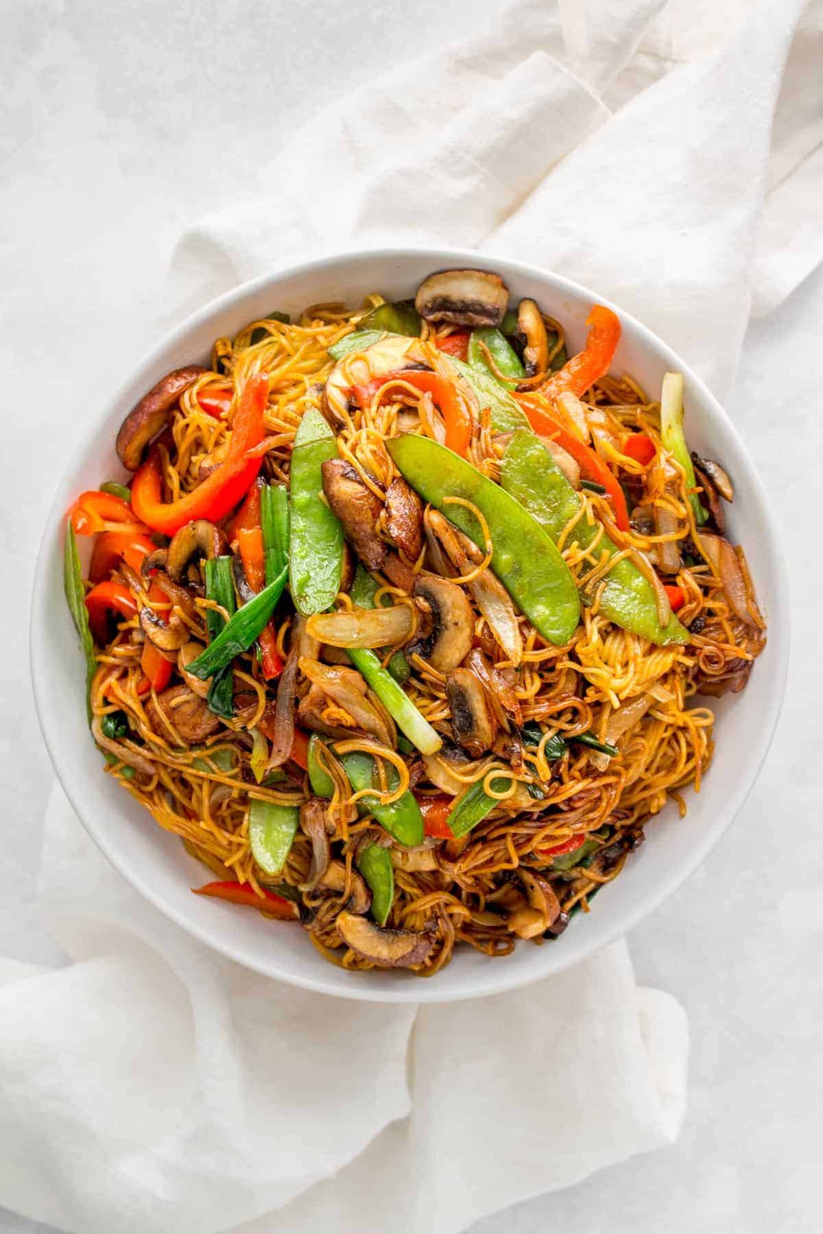 A large plate of soy sauce pan fried noodles with vegetables.