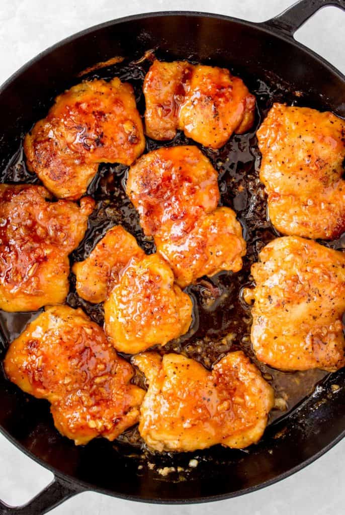 Close up of spicy honey garlic chicken thighs in a pan.
