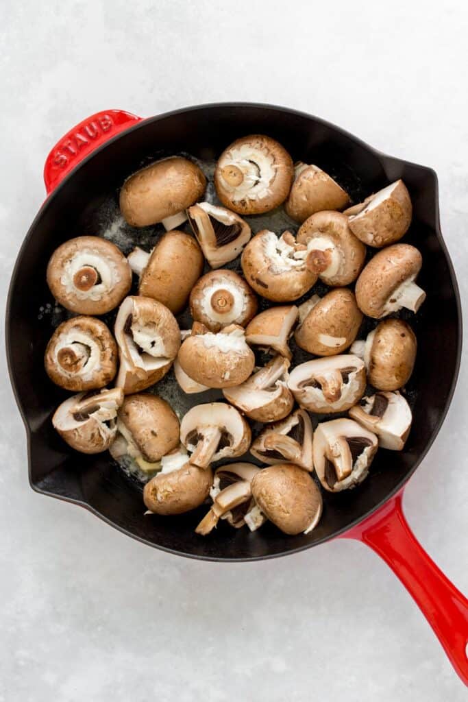 Mushrooms added to a skillet.