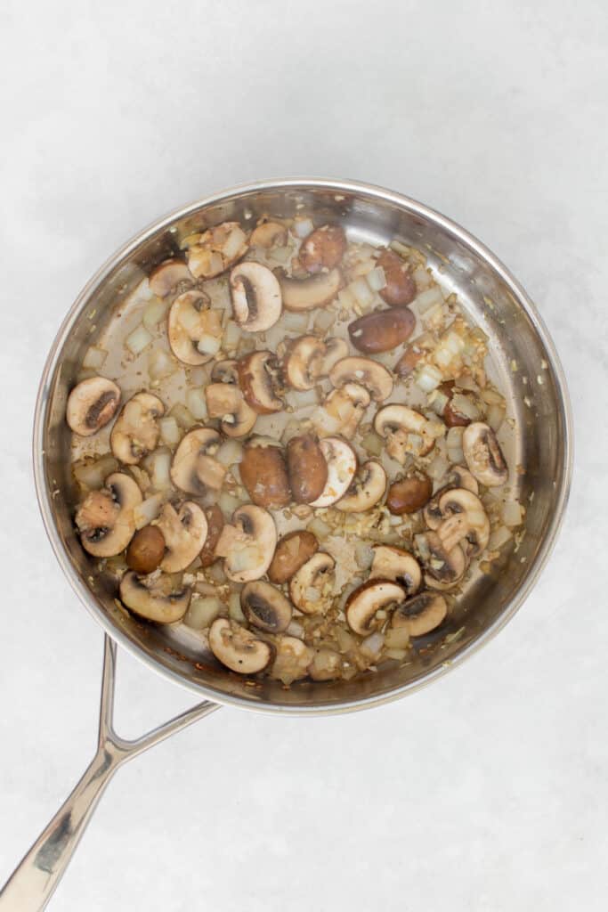 Onion, garlic, and mushrooms in a pan.