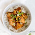 A bowl of pineapple chicken over top rice.