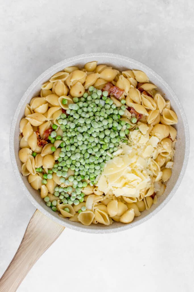 Peas and parmesan added to a pan.