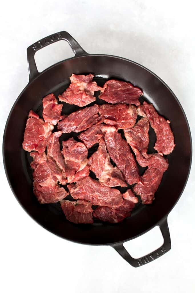 Sliced beef in a cast iron.