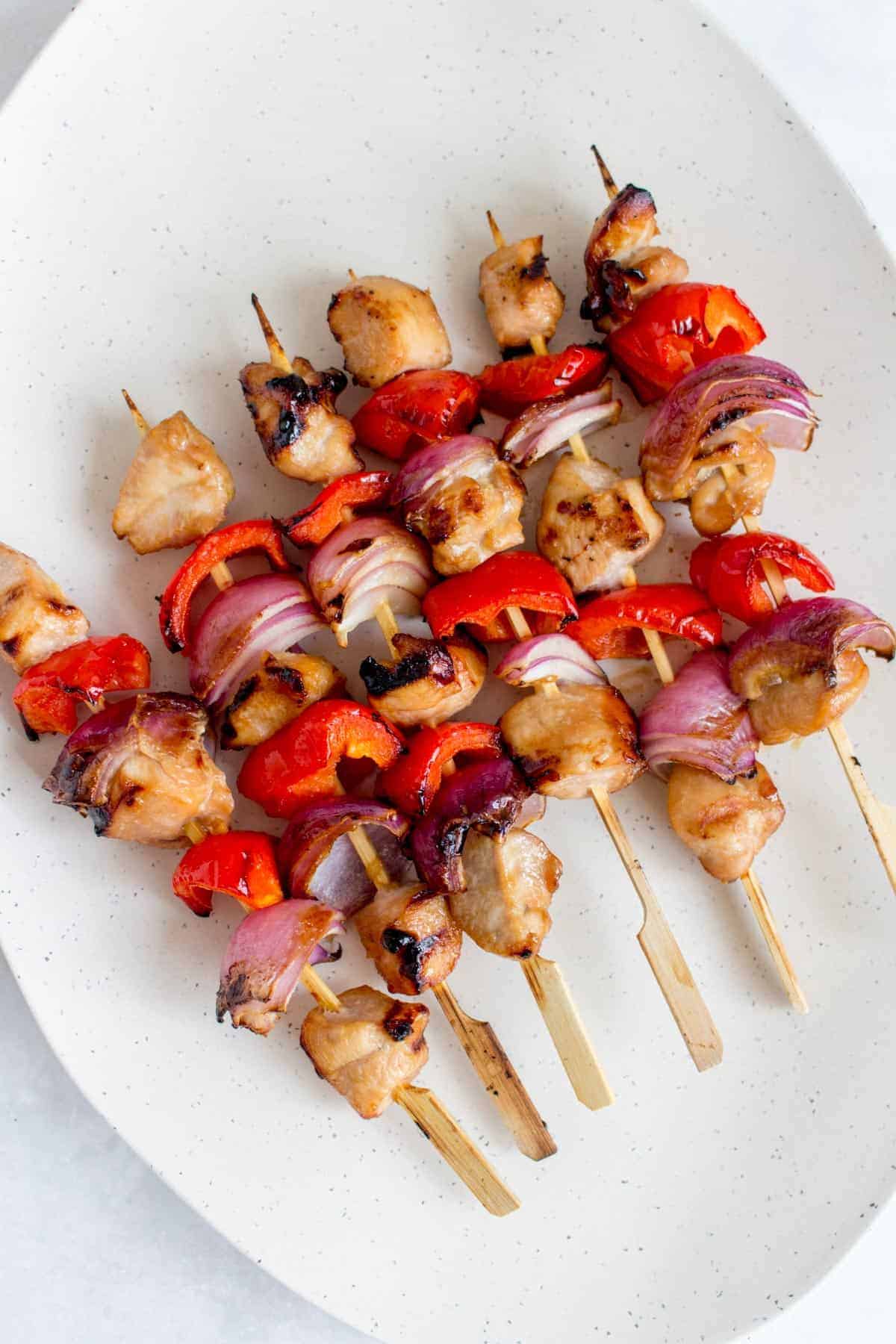 Honey garlic chicken skewers on a platter.